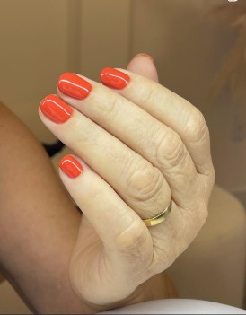 Esmaltação laranja vibrante em unhas curtas
